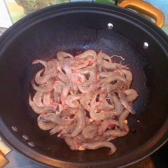 然后倒入河虾里面翻炒。