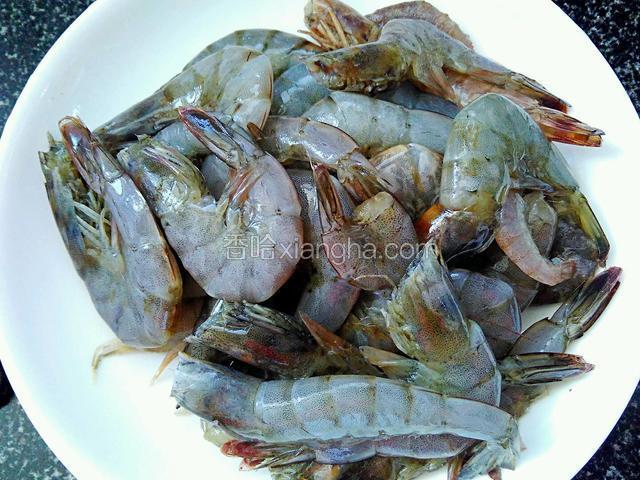 将河虾剪去头须和虾脚，用水洗净沥干水份。大葱切碎、蒜头和生姜切片。