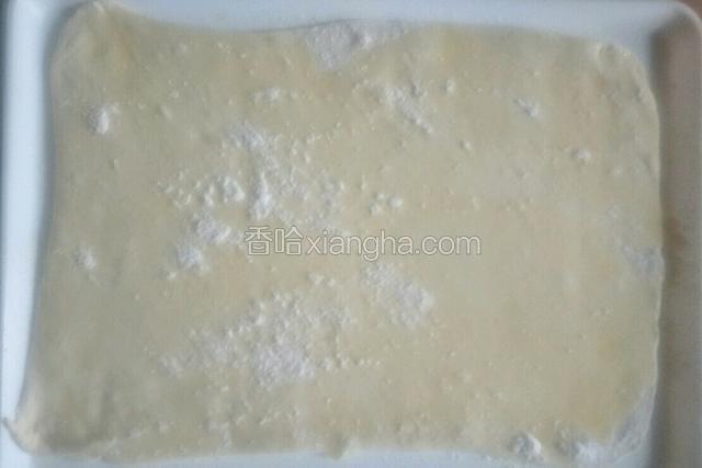 把面团擀成长方形薄饼，
刷一层玉米油撒适量干面粉